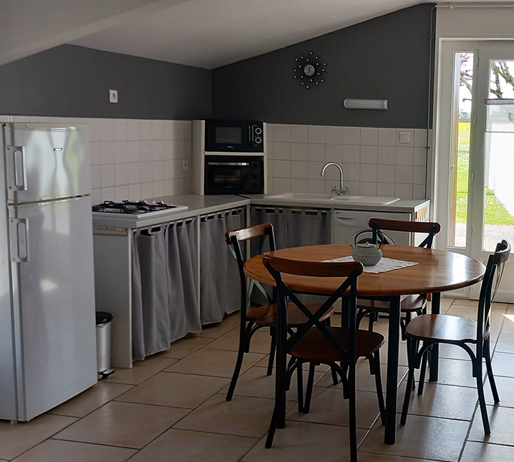 Séjour avec cuisine ouverte et canapé convertible du Gîte de la Seugne